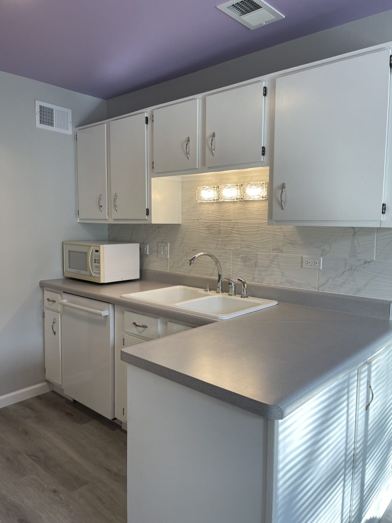 a kitchen with white cabinets and a microwave