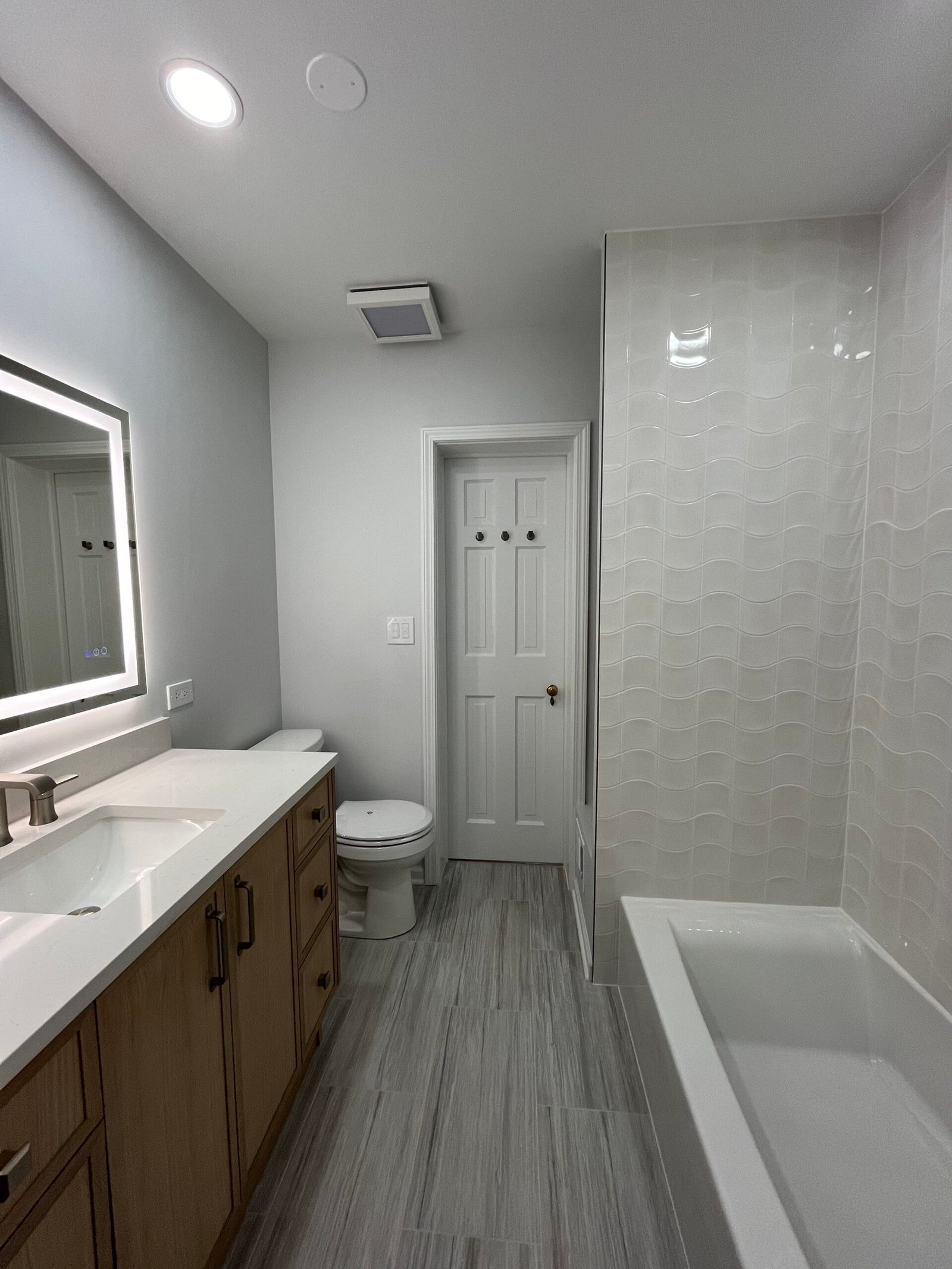 Updated bathroom with premium vanity, lighting, and bathtub finishes